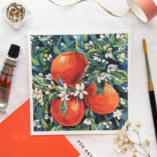 Framed artwork of oranges and flowers on a white background