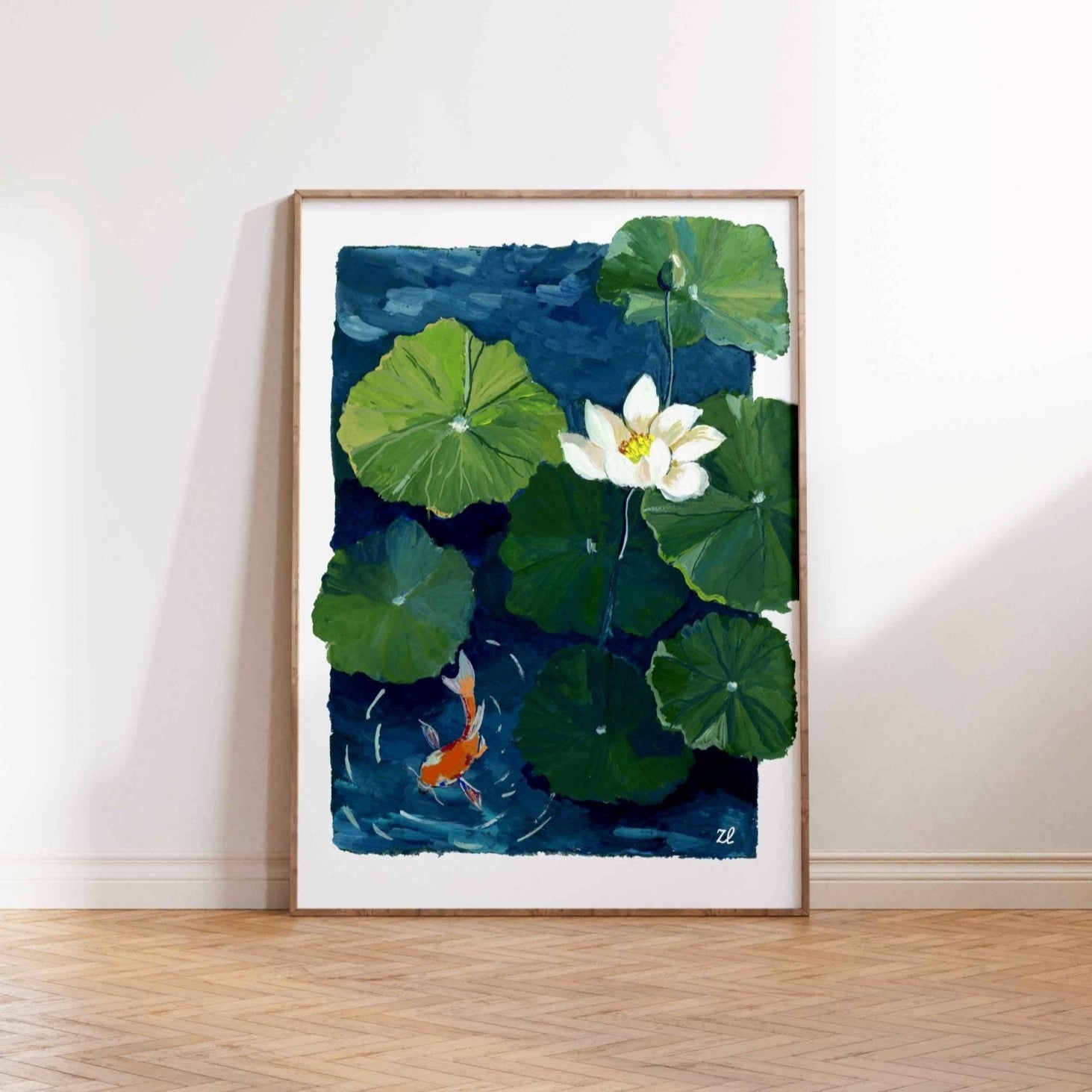Framed artwork of a watercolor painting of a white lotus flower and green lily pads with a goldfish on a blue background.