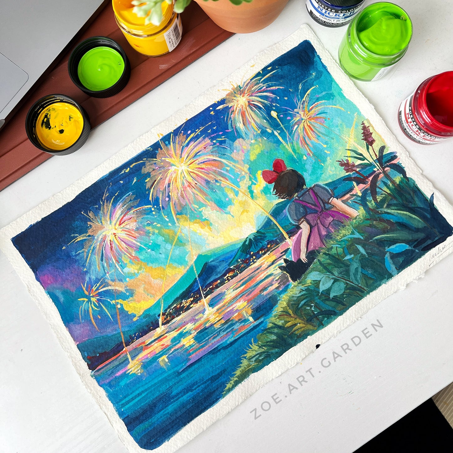 Colorful artwork of a woman on a swing with fireworks, surrounded by art supplies on a desk.