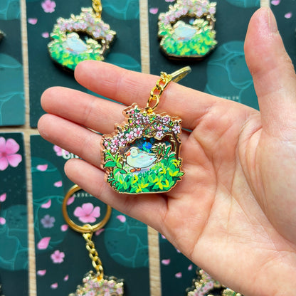 Hand holding a colorful brooch with more brooches on a patterned background