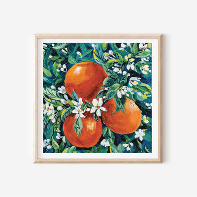 Framed artwork of oranges and flowers on a white background