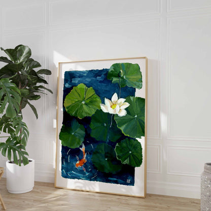 Framed artwork of a watercolor painting of a white lotus flower and green lily pads with a goldfish on a blue background.