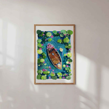 Framed artwork of a boat on water with lily pads on a white wall