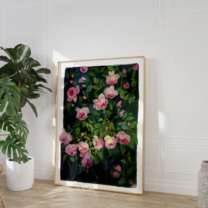 Framed floral artwork on a wall with a plant and vase in the background